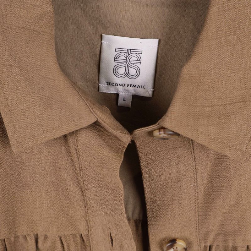 Närbild på märkesetikett Second Female i krage
