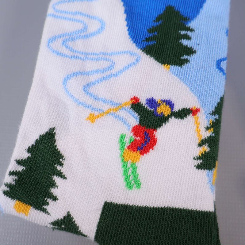 Närbild på skidåkare och granar på vita strumpor