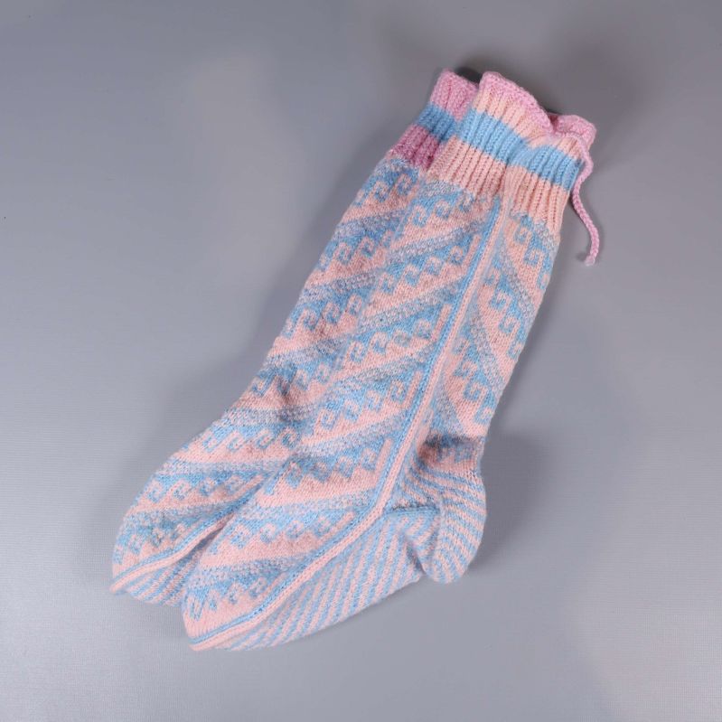 Stickade sockor i rosa och blått, liggande snett