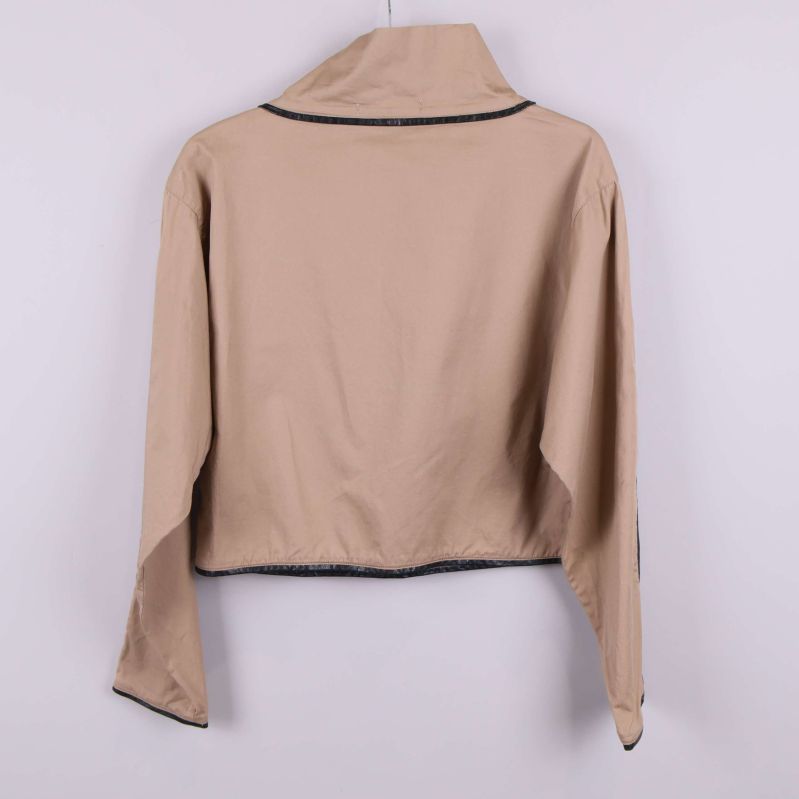 Baksidan av beige jacka med svart kant