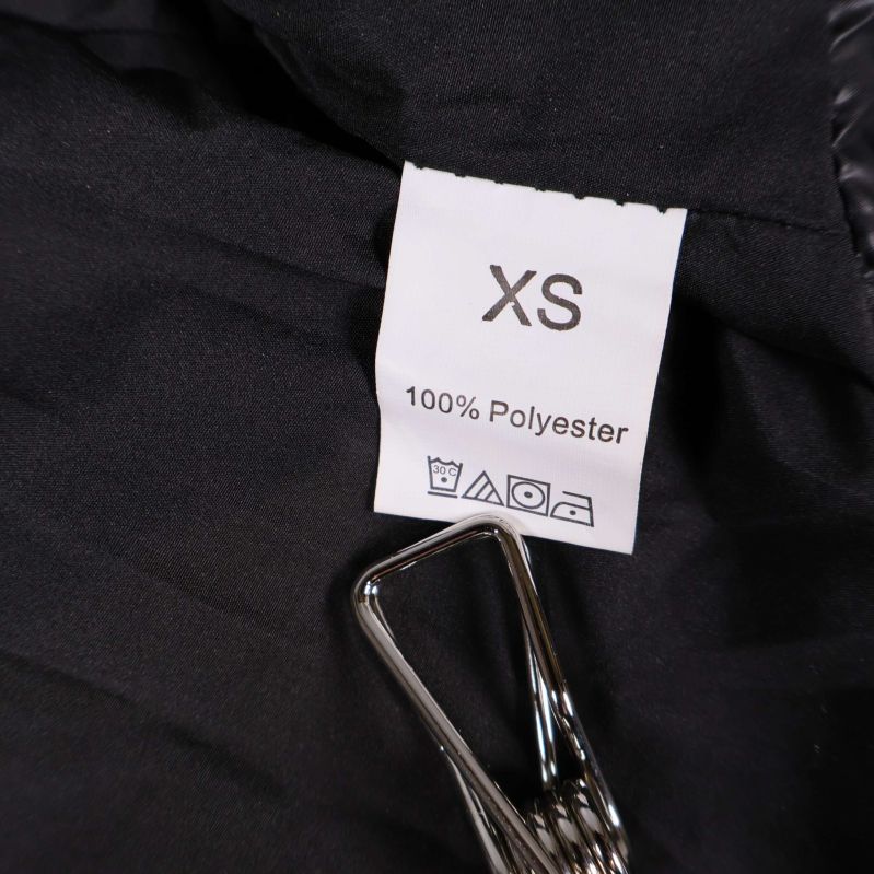 Materiallapp visar XS och 100% polyester