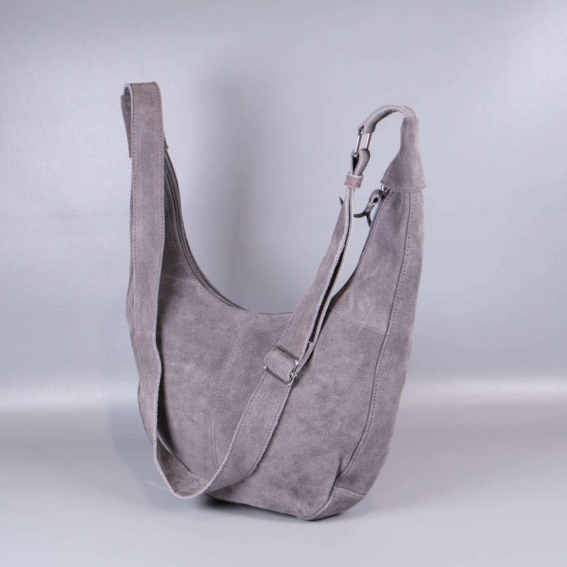 Grå axelremsväska med mockaliknande yta står upprätt