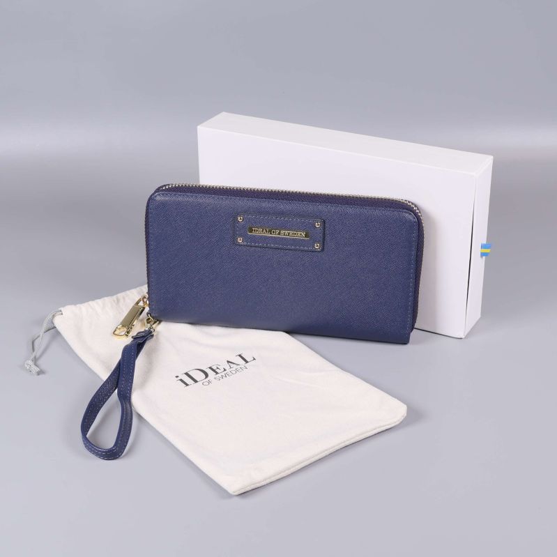 Blå plånbok med handledsrem, vit ask och tygpåse