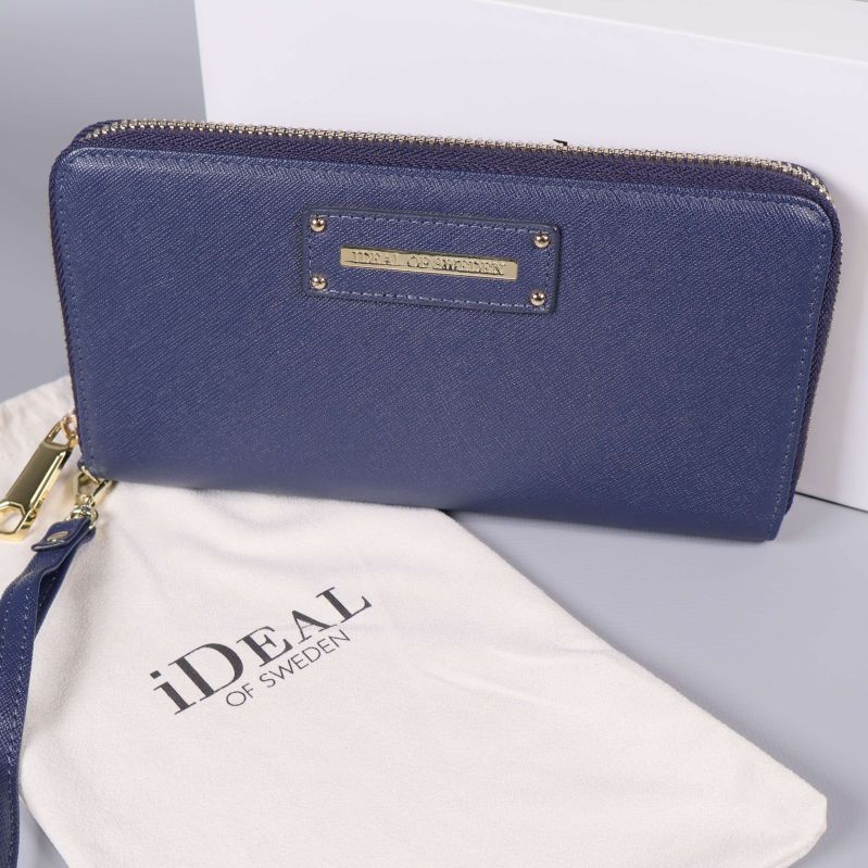 Närbild på blå plånbok och vit tygpåse