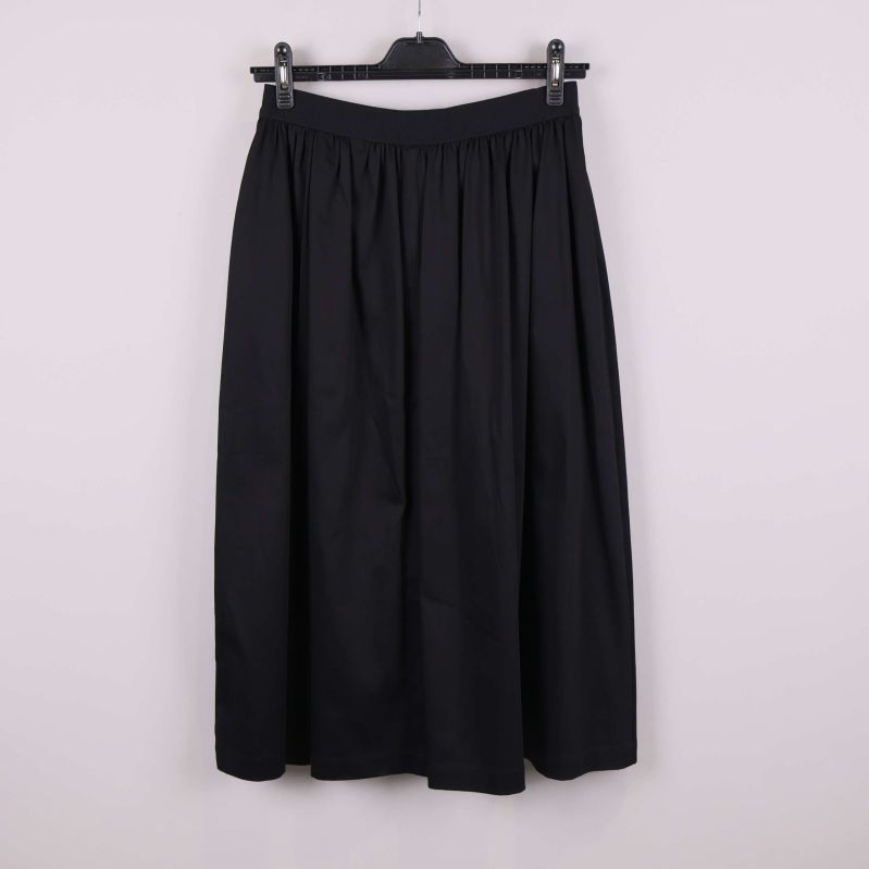 Svart kjol visad från baksidan mot ljus bakgrund