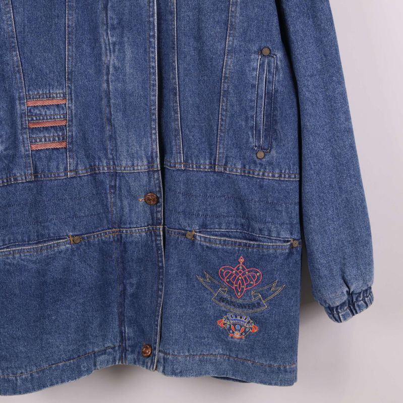 Detaljerad vy av broderat motiv på nedre delen av jeansjackan