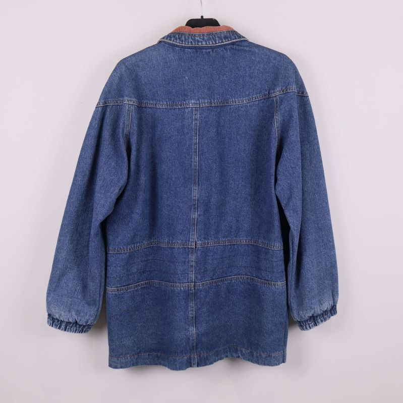 Baksidan av blå oversized jeansjacka med elastiska ärmslut