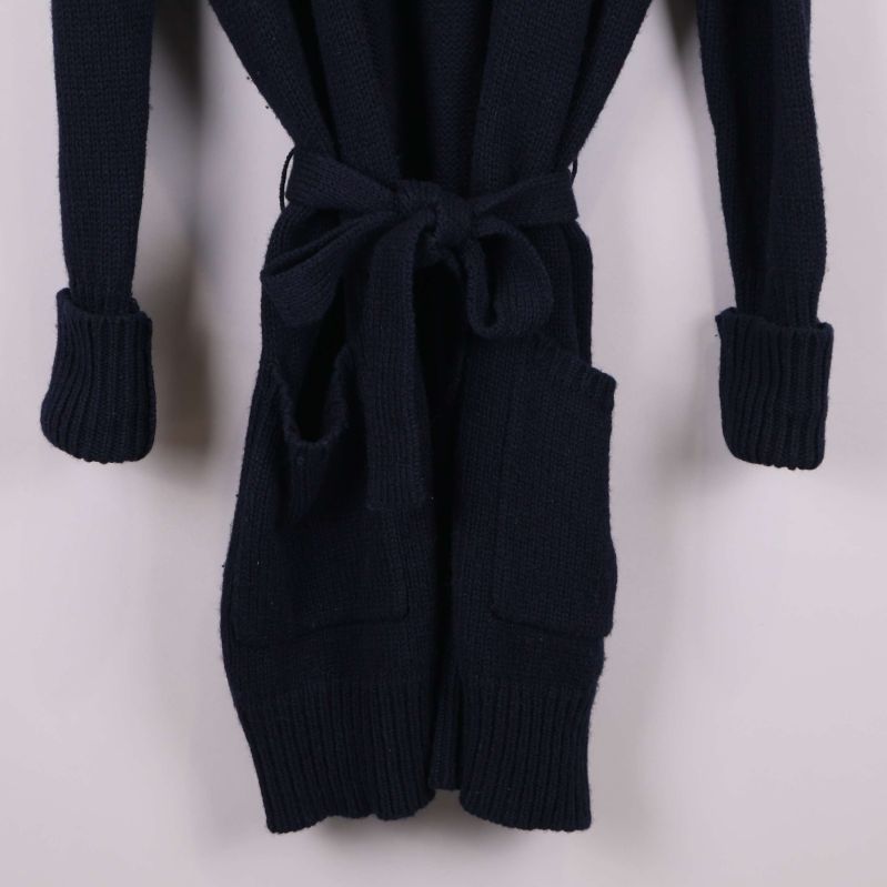 Närbild på fickor och skärp på koftans framsida