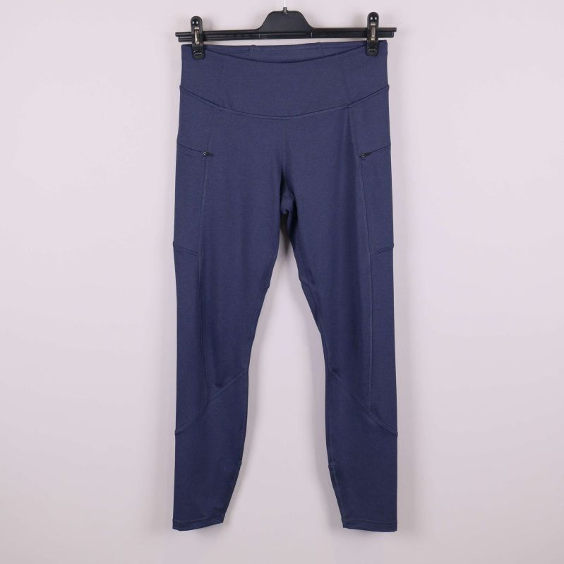 Framsida av blå träningstights på galge mot ljus bakgrund