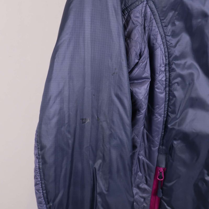 Närbild på mörkblå ärm med små märken