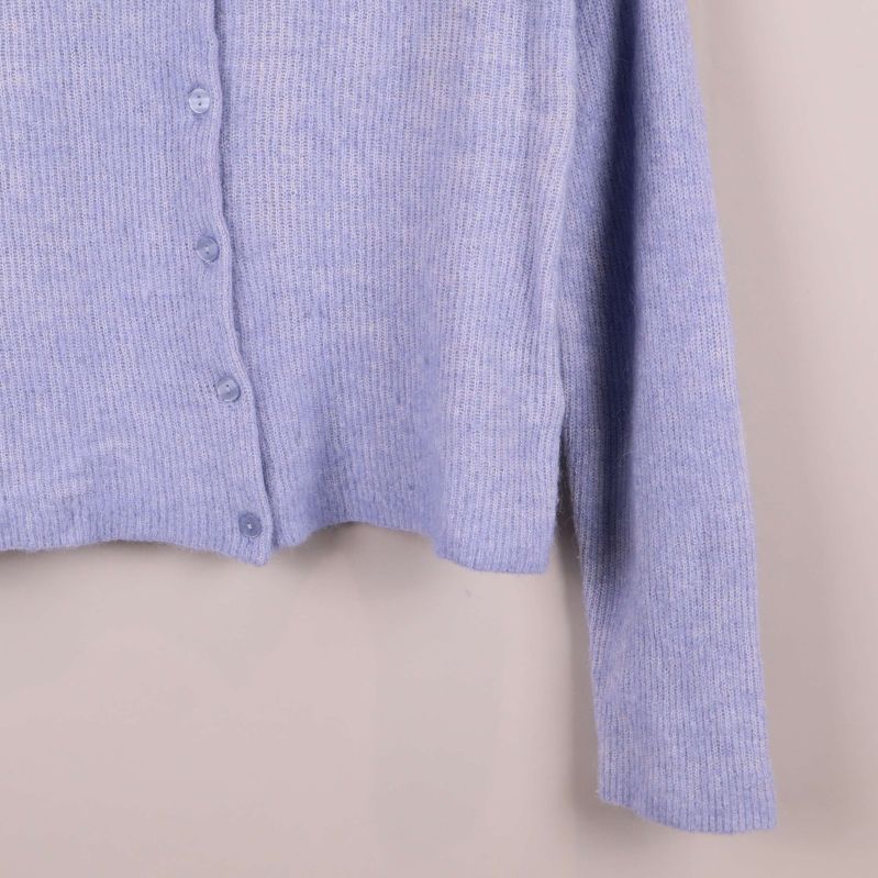 Närbild på nederkant och ärm på ljuslila kofta