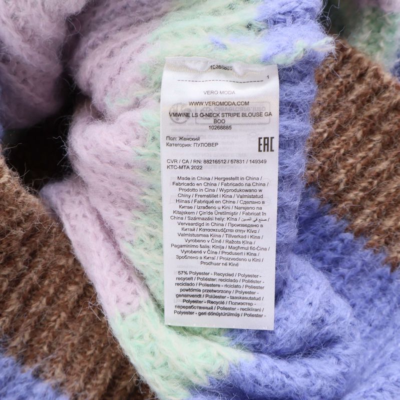 Materialetikett med sammansättning och skötselråd på stickad tröja