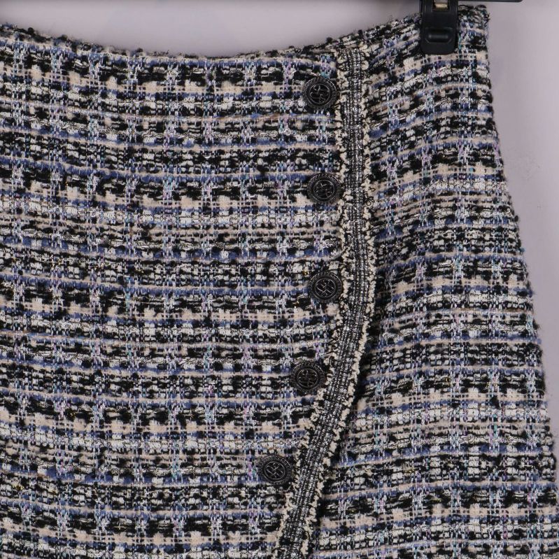 Detaljbild på knappar och mönster framtill på kjolen