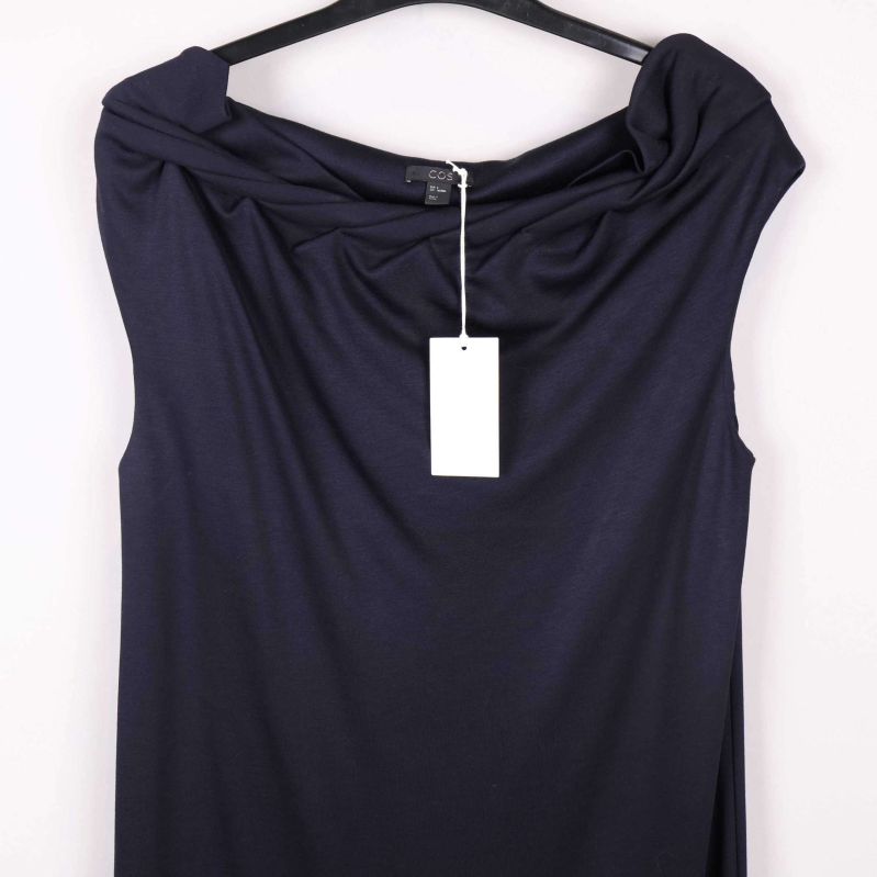 Detalj draperad halsringning och etikett