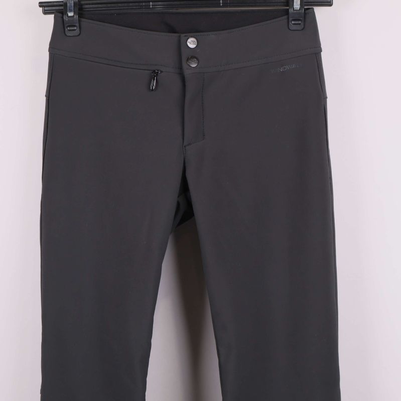 Närbild på midja och knappar på mörkgrå byxa