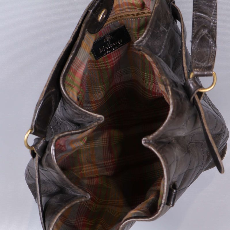 Öppen väska visar rutigt tygfoder och innerficka