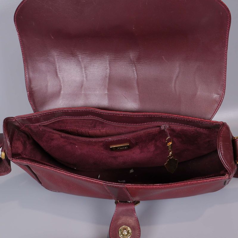Väskans insida i vinrött med fack och dragkedja