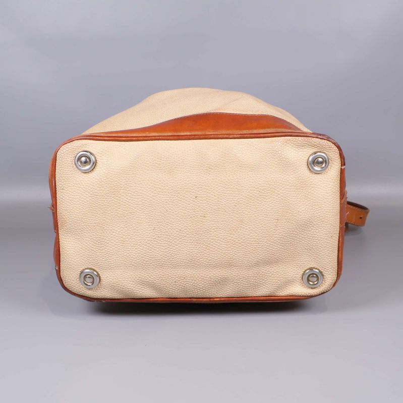 Väskans botten med metallfötter och canvastextur