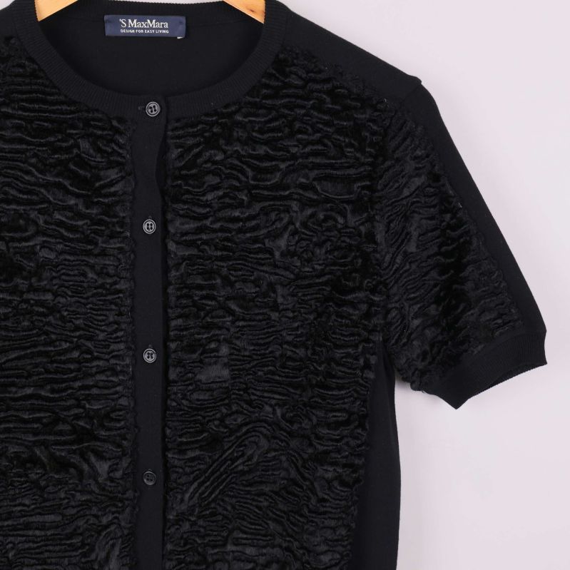 Halvnärbild av svart kofta med struktur och knappar framtill