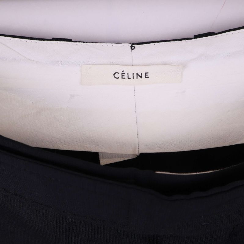 Närbild på Céline-märkesetikett på byxorna