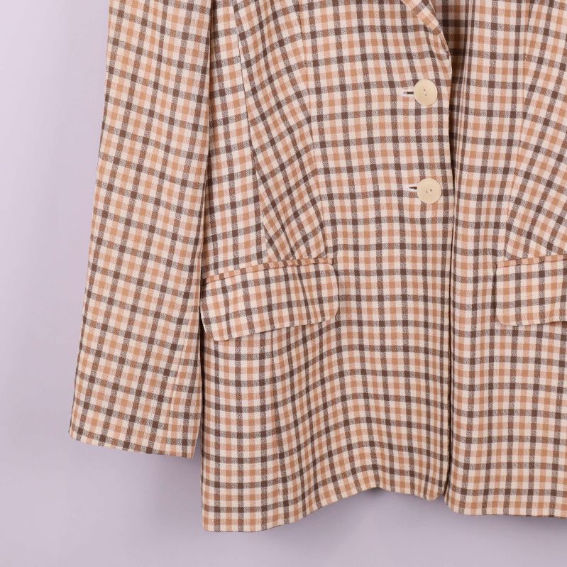 Detaljbild på nedre delen av ärm och ficka av rutig kavaj