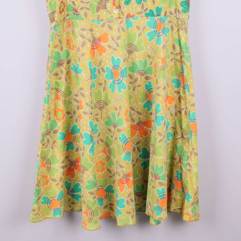 Nederdel av gul klänning med blommigt motiv