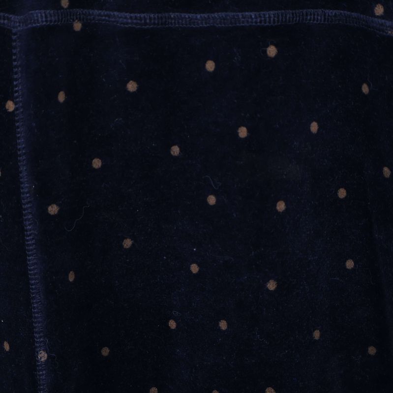 Närbild på små prickar mot svart velourtyg