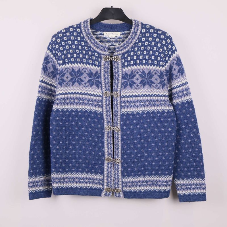 Blåvit kofta med mönster och dekorativa spännen framifrån