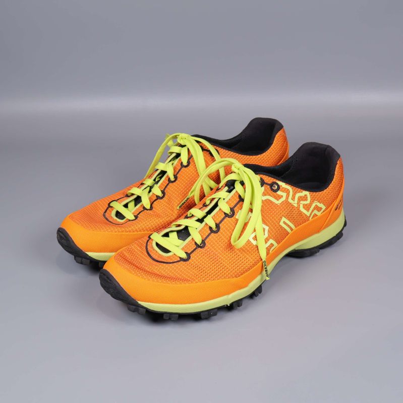 Två orange terrängskor med gula snören i vinkel