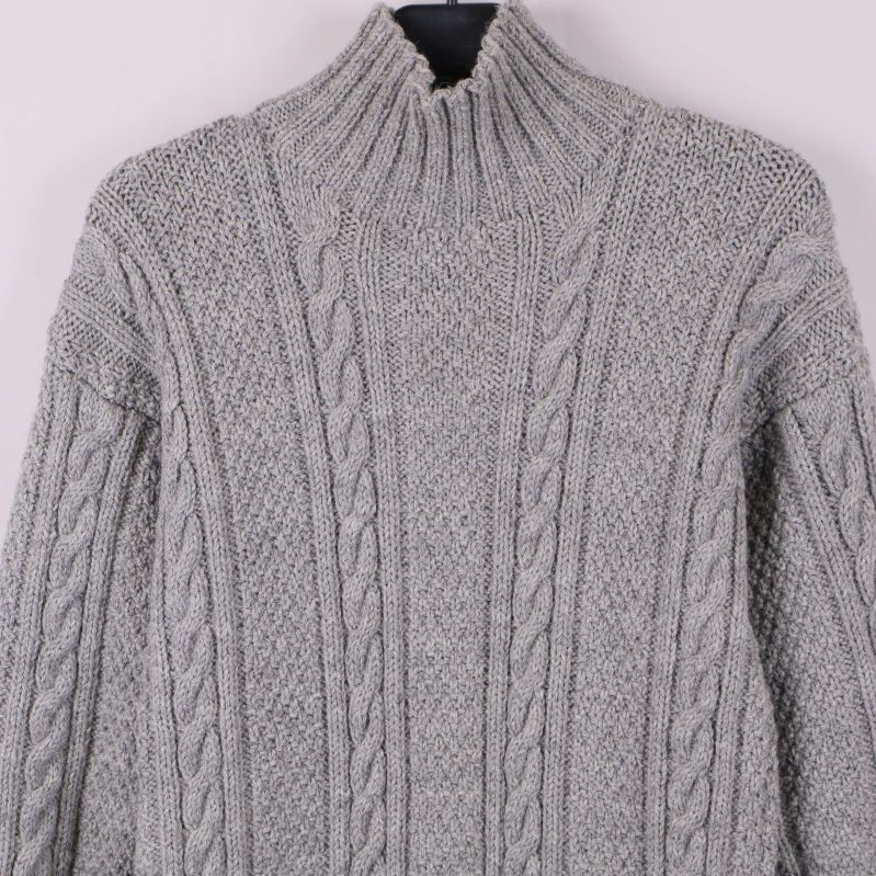 Närbild på den höga kragen och kabelstickat mönster
