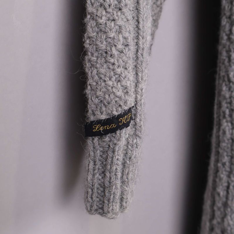 Närbild på ärmslut med svart märke och gul text