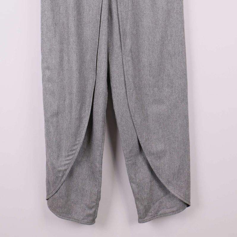 Närbild på benens omlottfinish på grå byxa