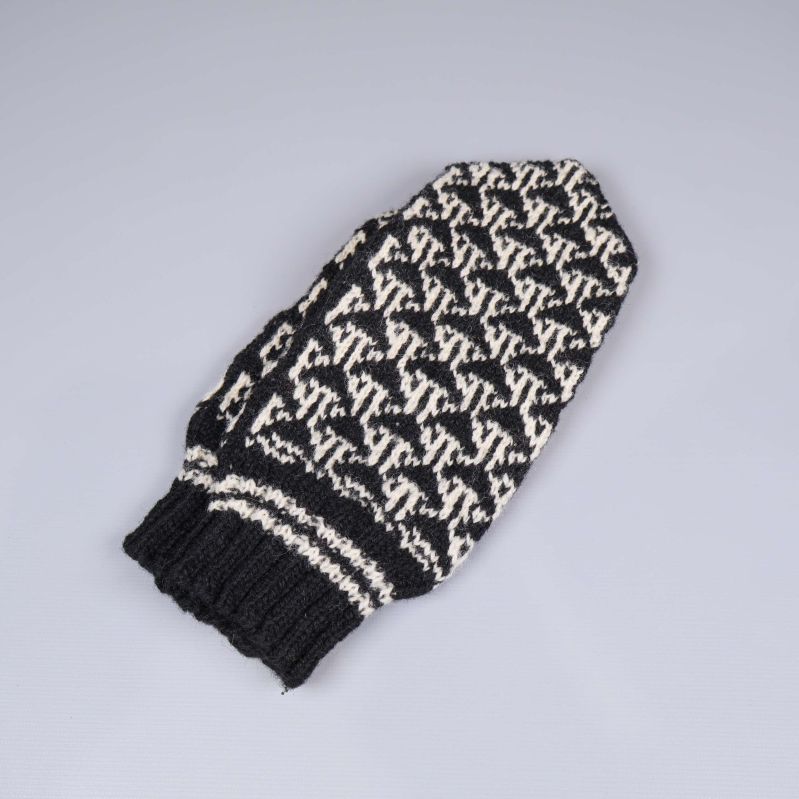 Svartvit stickad tumvante sedd från sidan