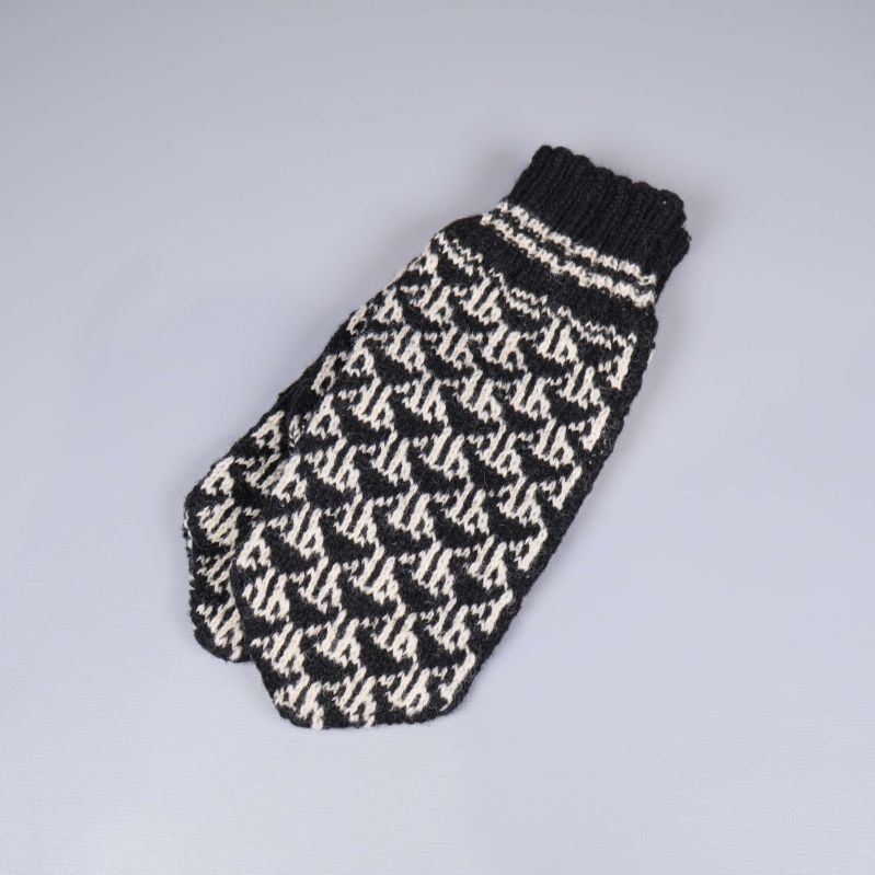 En svartvit stickad tumvante med grafiskt mönster