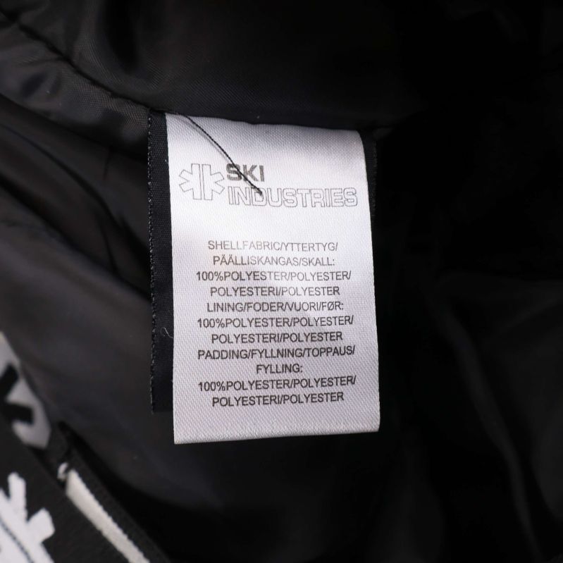 Materiallapp som visar 100% polyester i byxan