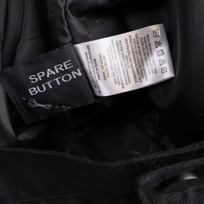 Tvättråd och extraknapp i närbild på insidan av byxan