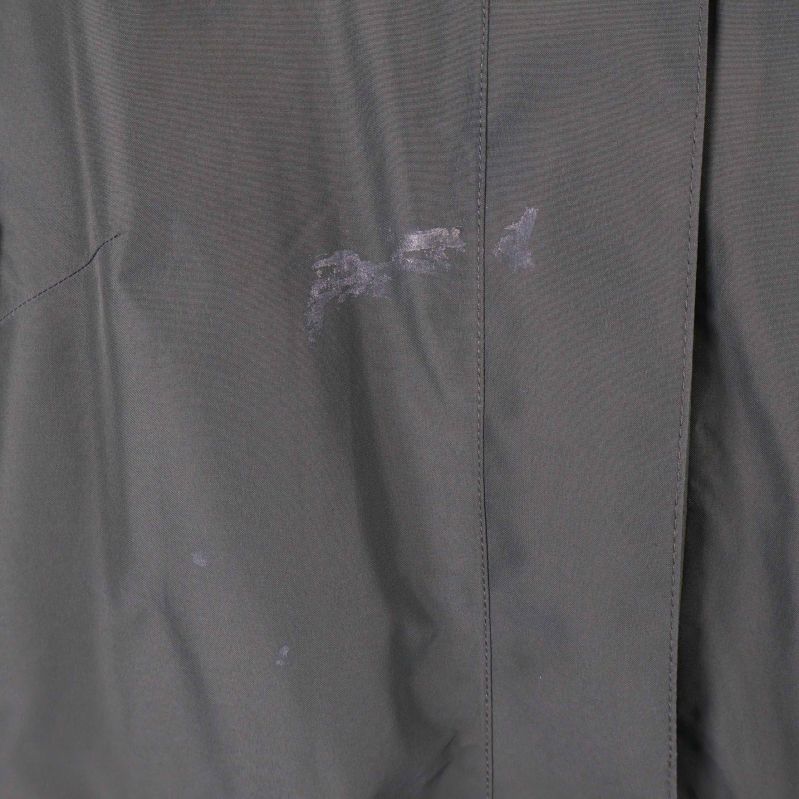 Fläckar synliga på framsidan av olivgrön parkas