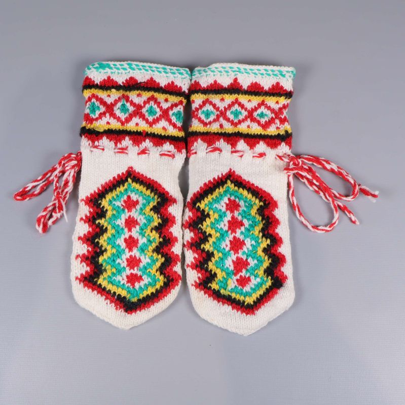 Två stickade tumvantar med livligt mönster ovanifrån