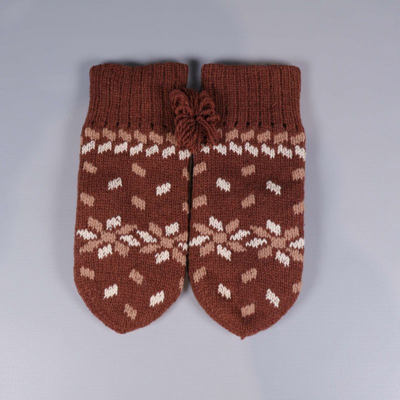 Framsidan av bruna stickade tumvantar med mönster
