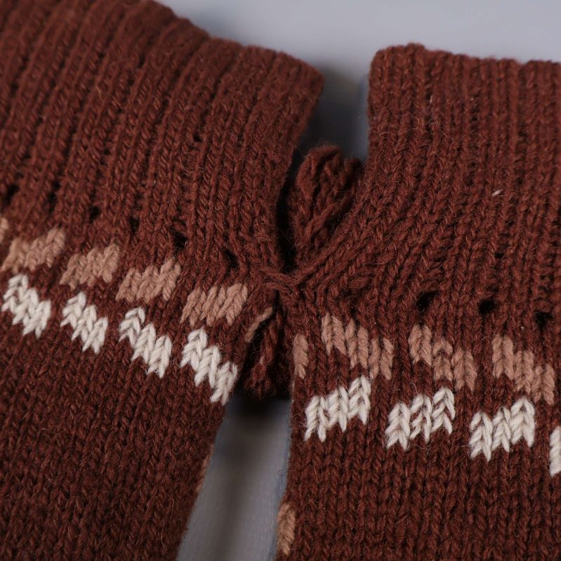 Närbild på mudd och garnrosett på tumvantar