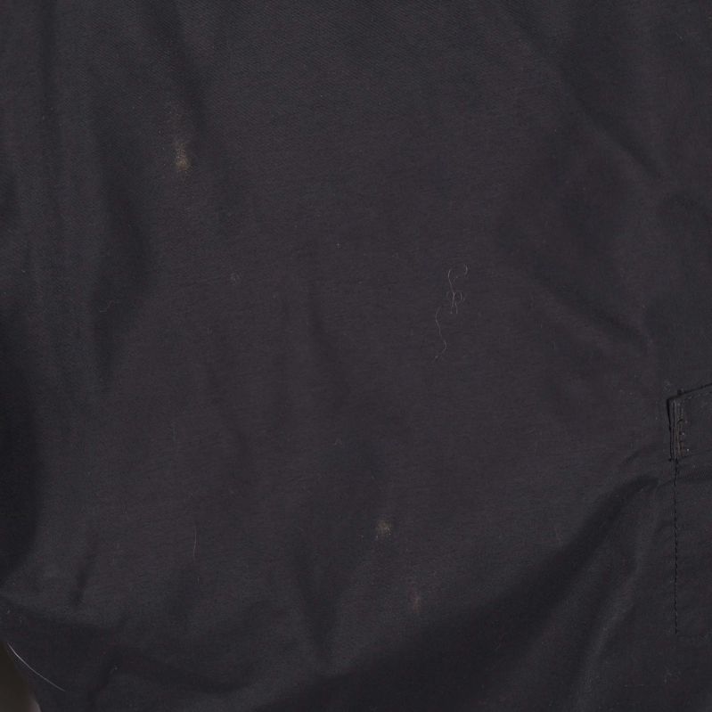 Närbild på svarta tyget med små slitage och noppor