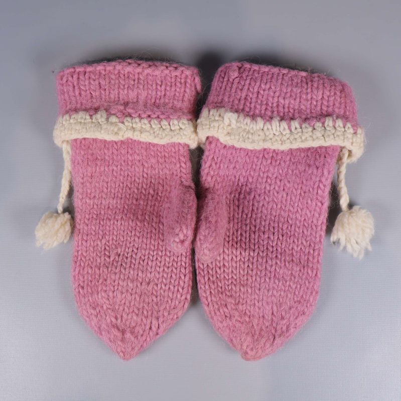 Baksida på rosa stickade tumvantar med vit kant