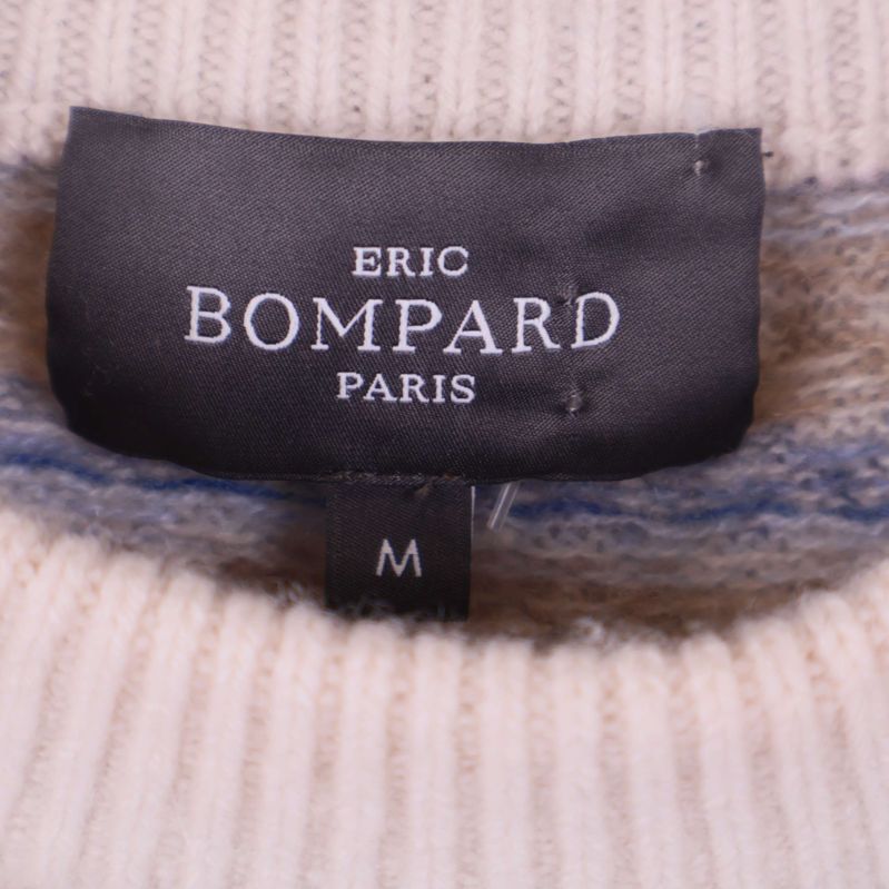 Närbild på svart etikett med texten Eric Bompard Paris