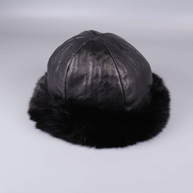 Svart mössa med bred pälskant sedd snett framifrån