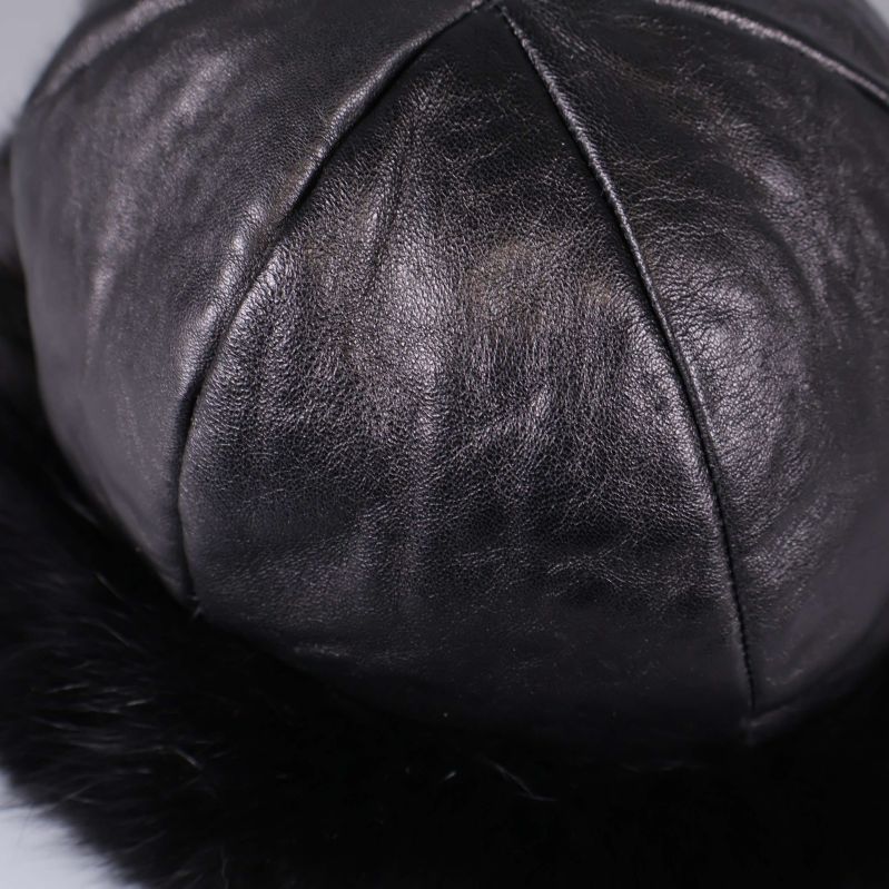 Närbild på mössans släta svarta skinnmaterial