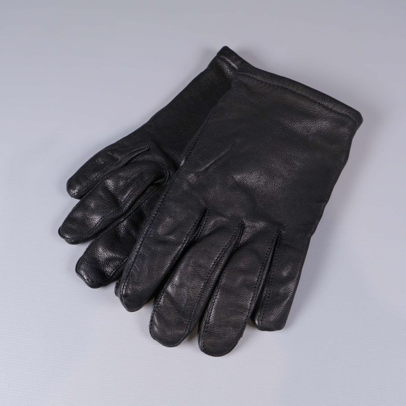 Ett par svarta skinnhandskar liggande på grå yta