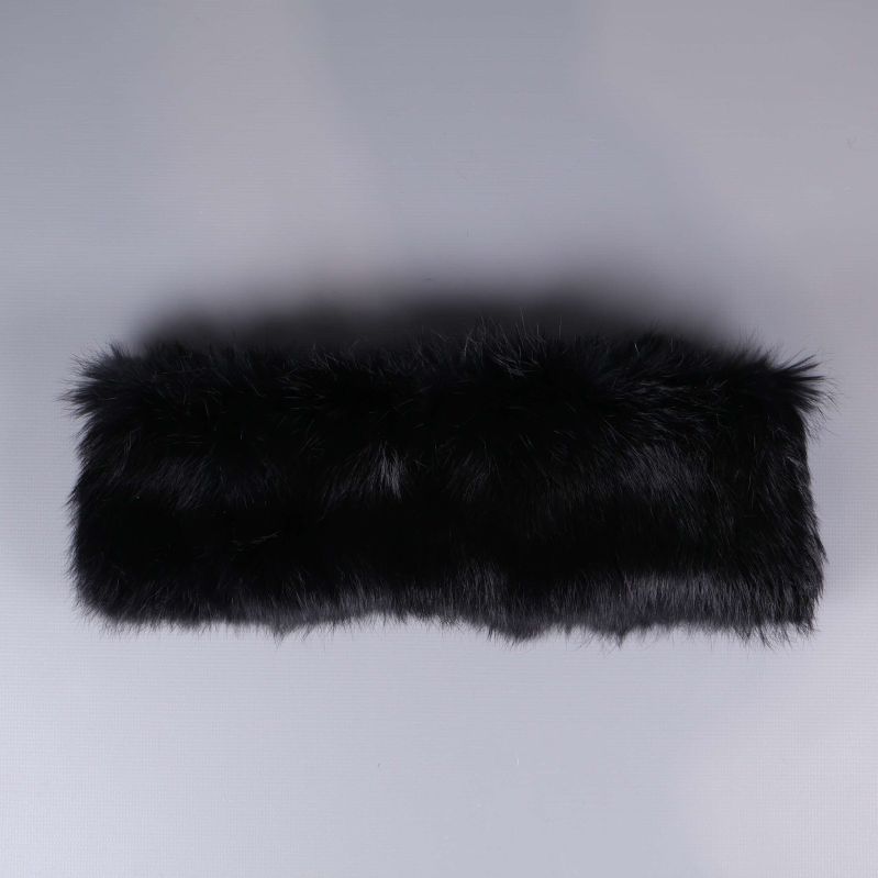 Svart pälsbåge liggande mot ljus bakgrund