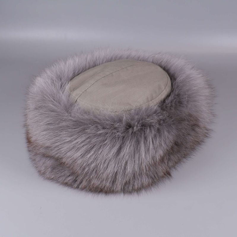 Grå mössa med bred fluffig pälsdetalj liggande