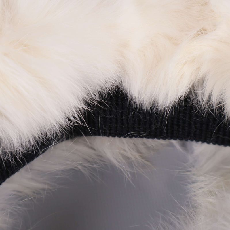 Närbild på vit fluffig yta och svart fodrad insida