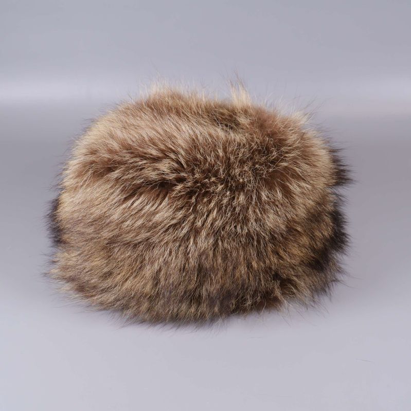 Rund fuskpälsmössa i bruna nyanser mot grå bakgrund